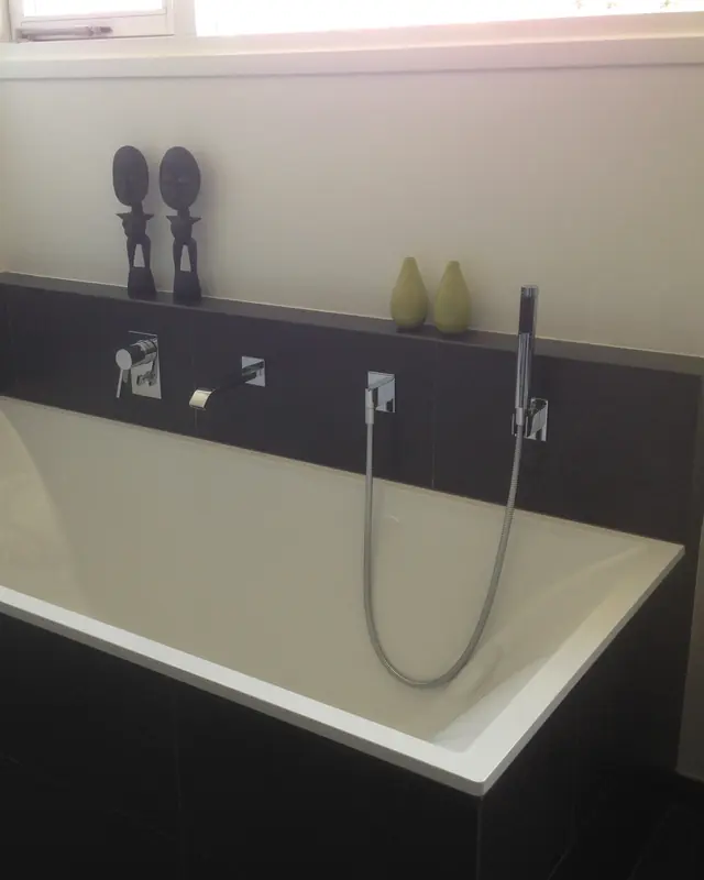 Badkamer met ingebouwd ligbad, inbouwkranen en handdouche