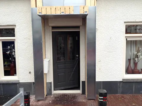 Zinken luifel en zijwanden rond een voordeur